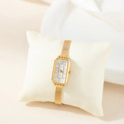 Reloj Rectangular Celeste dorado presentado sobre un cojín