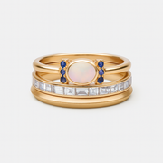 Trío de Anillos Aurora Azul dorado con piedra ovalada y cristales sobre fondo blanco