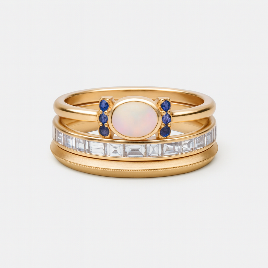 Trío de Anillos Aurora Azul dorado con piedra ovalada y cristales sobre fondo blanco