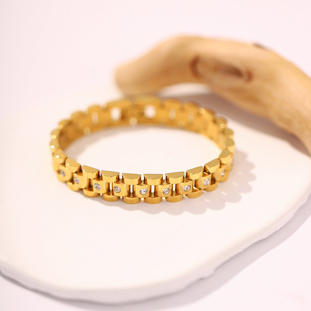 Pulsera Eslabones Brillantes Elora sobre una superficie rosa clara