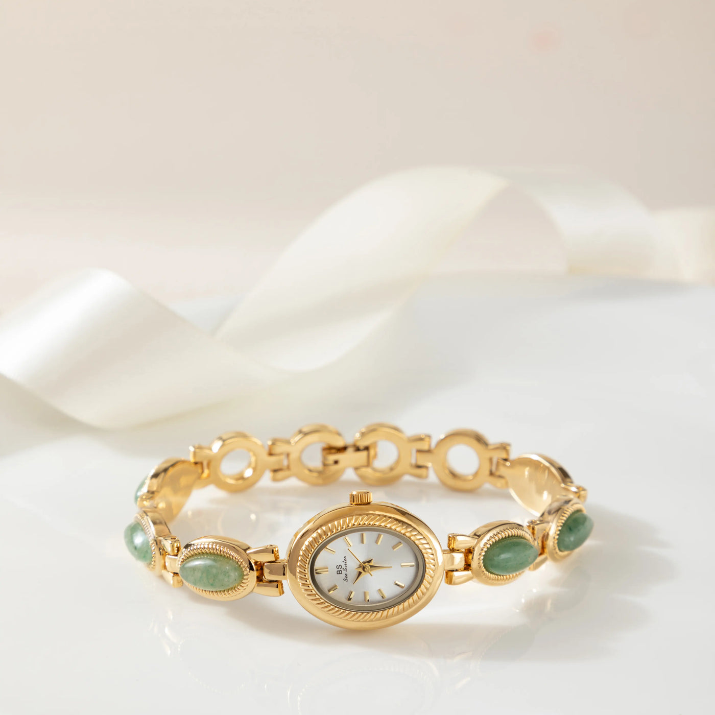 Reloj Rectangular Nerina dorado sobre una superficie de color crema