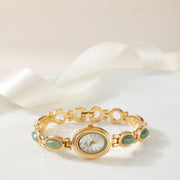 Reloj Rectangular Nerina dorado sobre una superficie de color crema