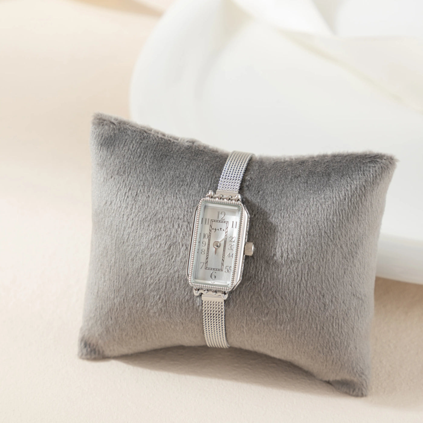 Reloj Rectangular Celeste plateado presentado sobre un cojín