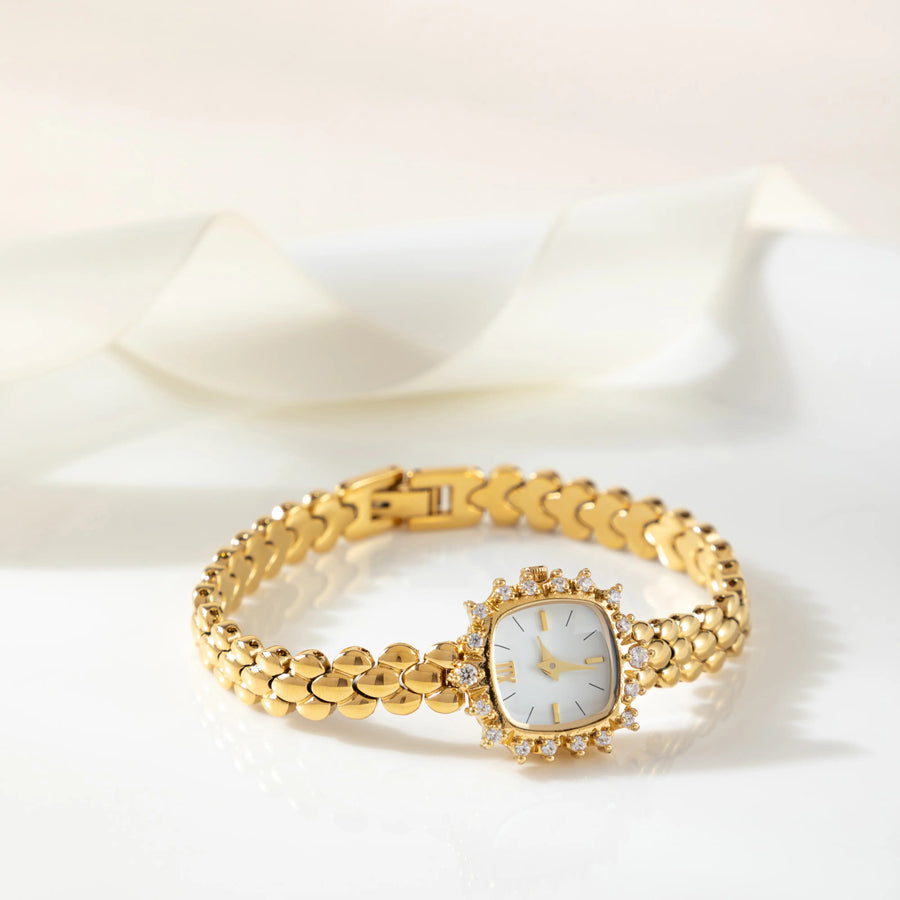 Reloj Brazalete Valeria dorado sobre una superficie de color crema