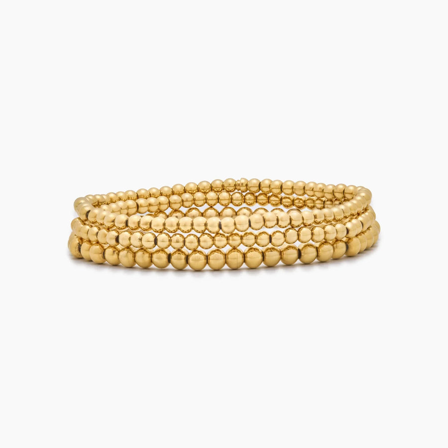 Pulsera Triple Esferas Oriana dorada sobre fondo blanco