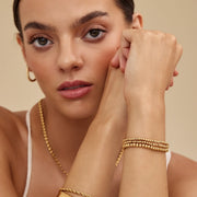 Mujer llevando la Pulsera Triple Esferas Oriana dorada