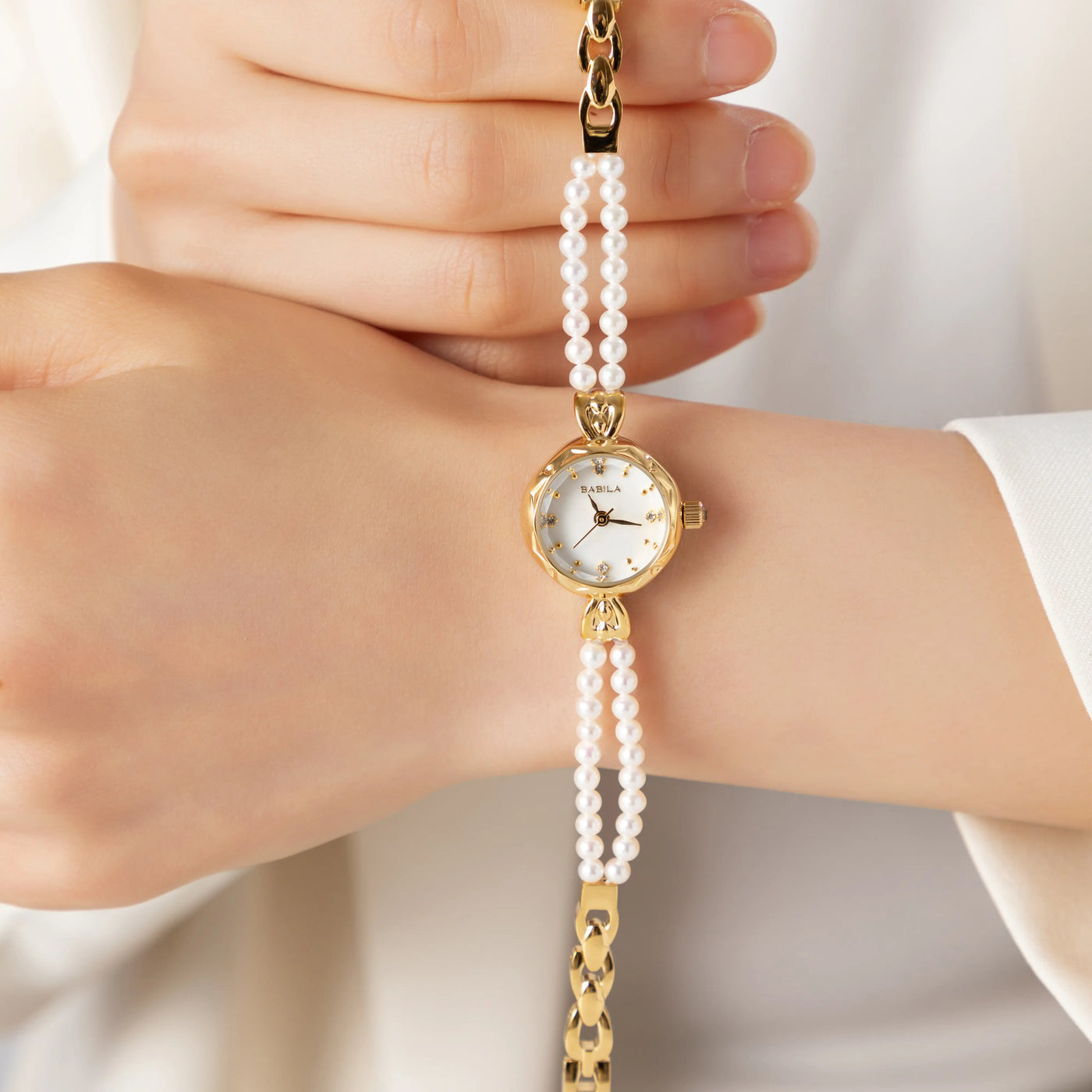 Mujer llevando el Reloj Perlado Mireya dorado en la muñeca