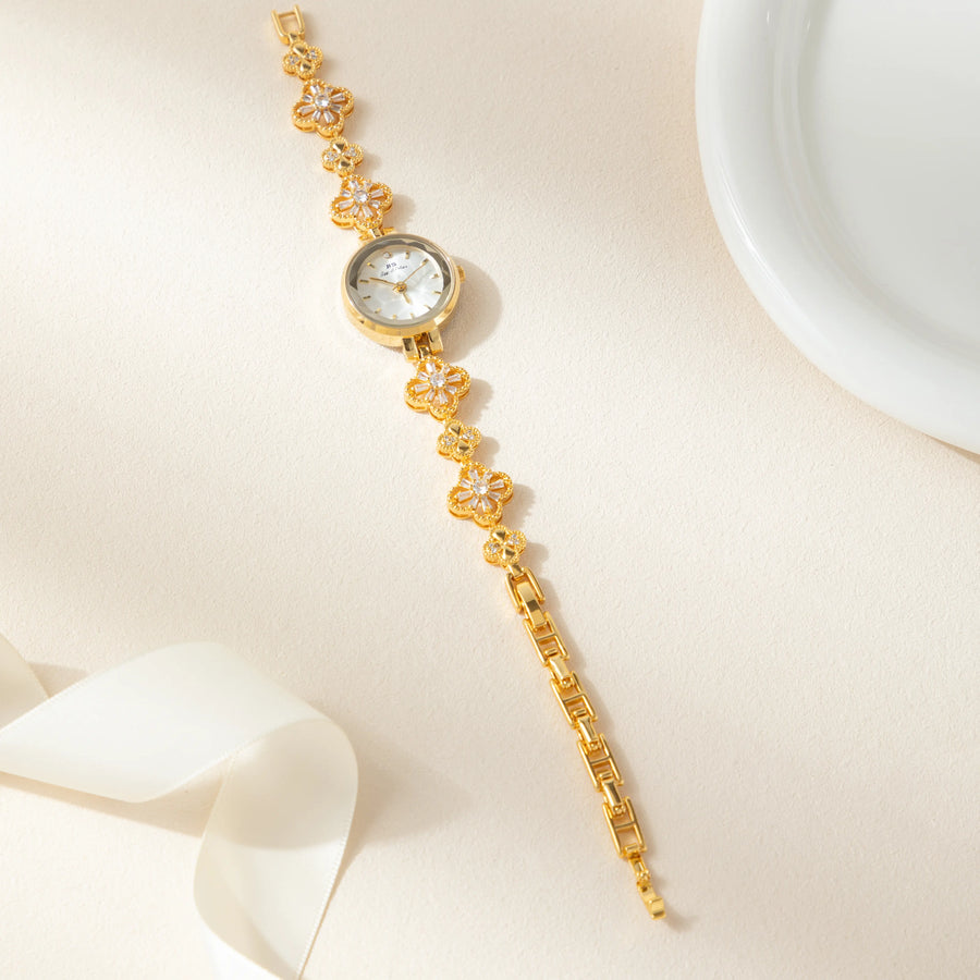 Reloj Floral Dalia dorado sobre una superficie de color crema