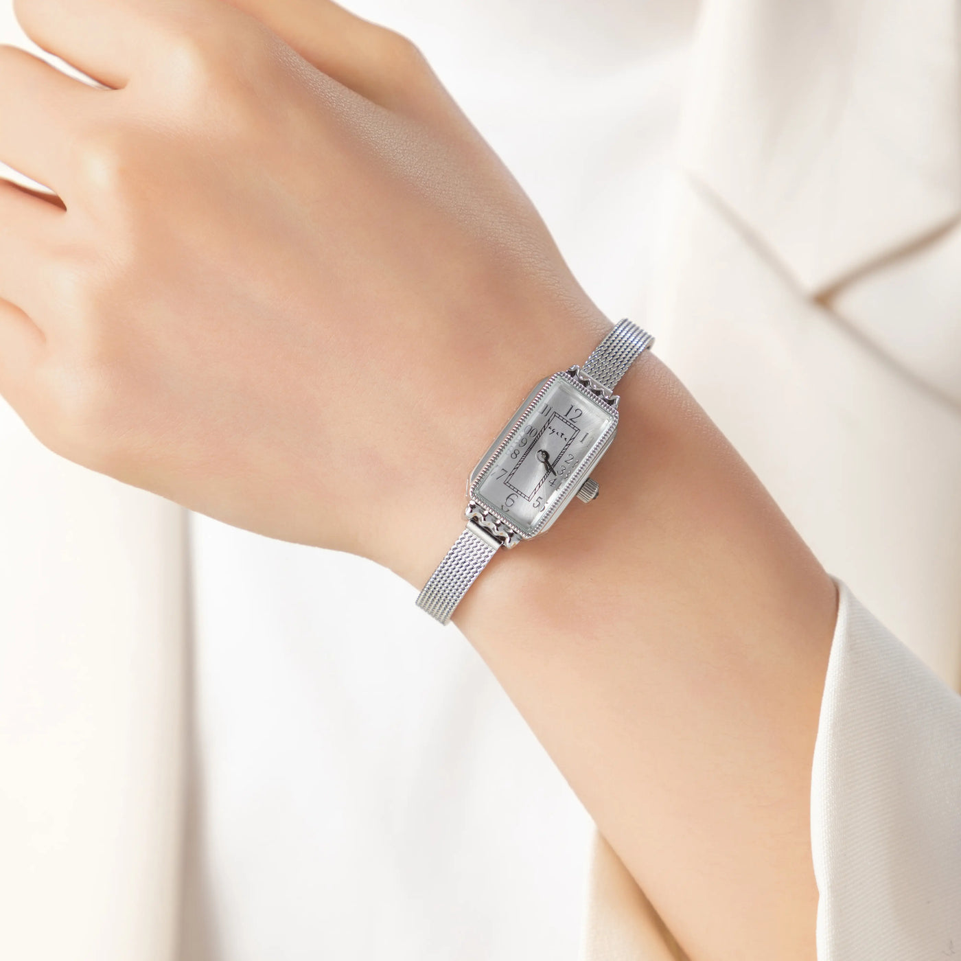 Reloj Rectangular Celeste plateado puesto en la muñeca