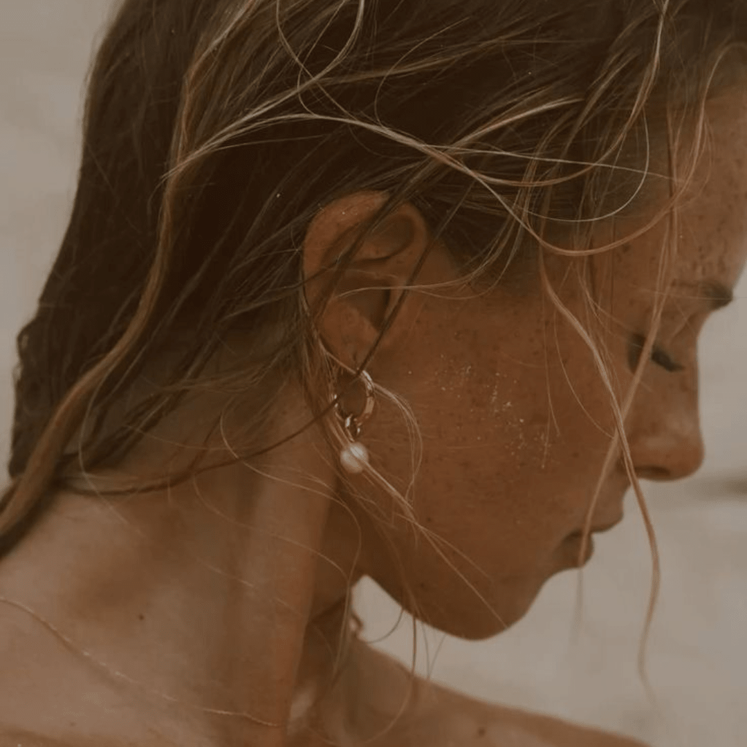 Aros Bella Perla dorados puestos en la oreja