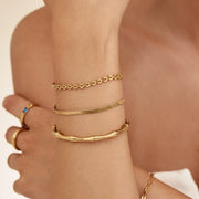 Mujer combinando varias pulseras Bambú Escultural Nayara doradas