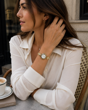 Mujer llevando el Reloj Floral Dalia dorado en la muñeca
