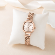 Reloj Cuadrado Roselia en oro rosa presentado sobre un cojín claro