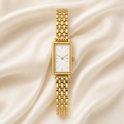 Reloj Rectangular Liora dorado con esfera blanca sobre satén claro