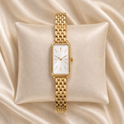 Reloj Rectangular Liora con esfera blanca presentado sobre un cojín claro