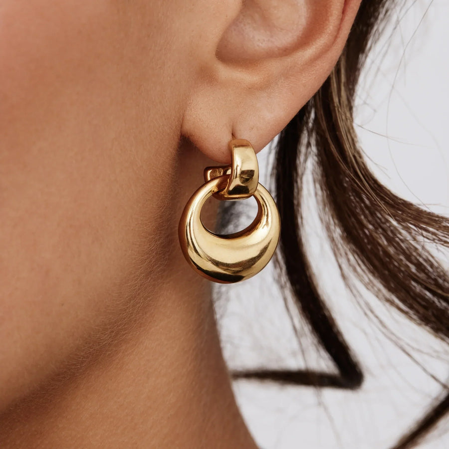 Detalle del Pendiente Gota Escultural Nerea dorado en la oreja