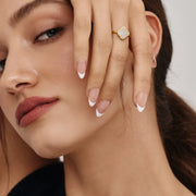 Detalle del Anillo Trébol Alba dorado lucido junto al rostro