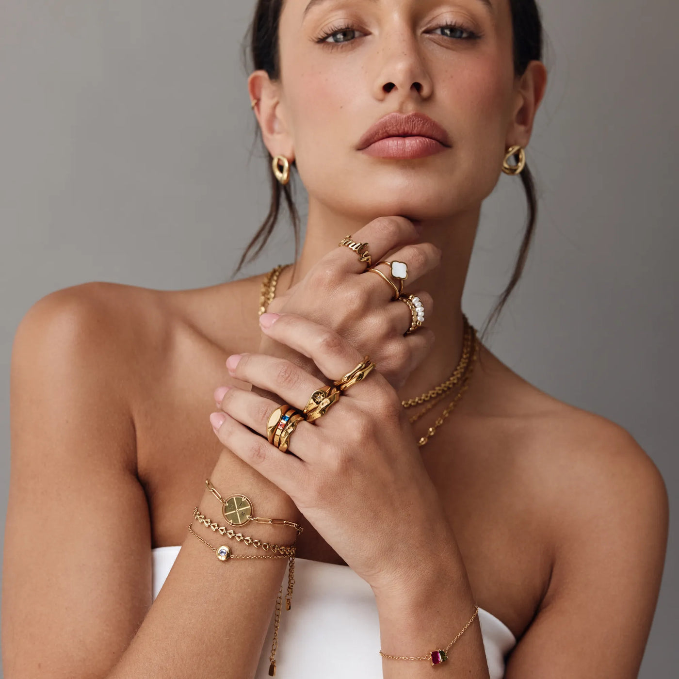 Modelo luciendo el Anillo Trébol Alba con varios anillos dorados