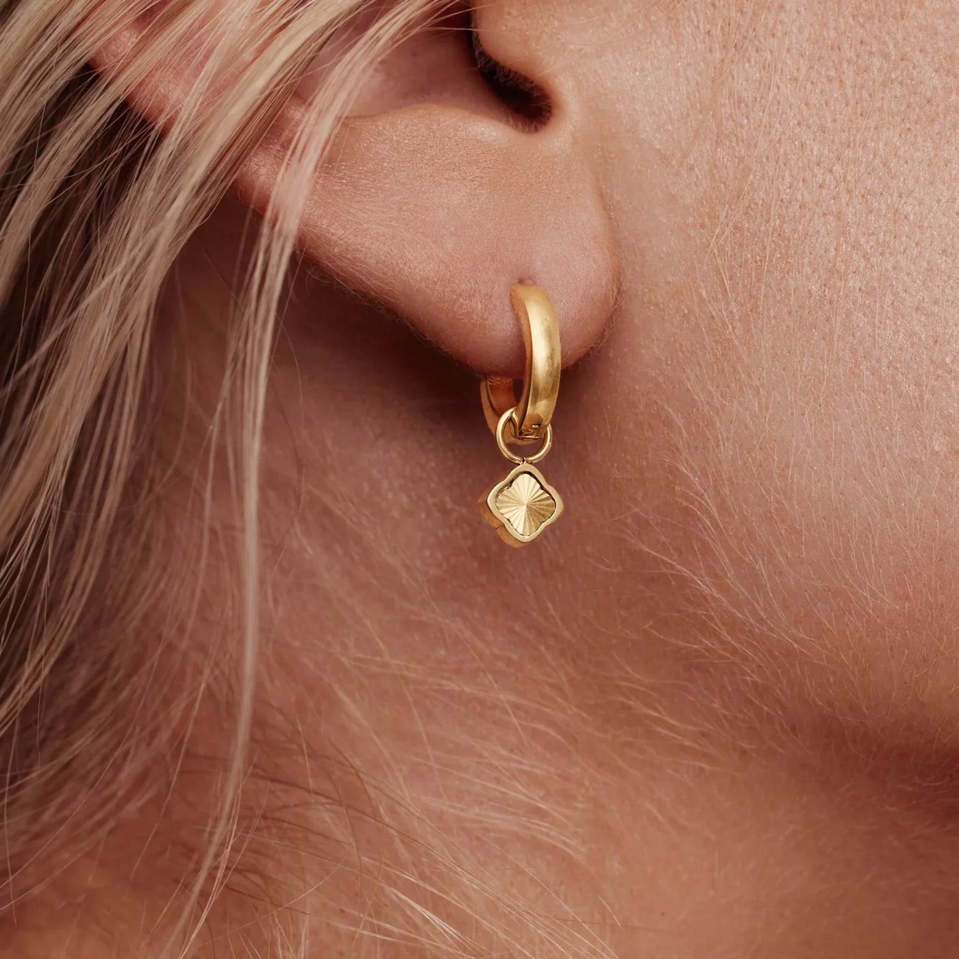 Detalle del Pendiente Huggie Trébol Amalia dorado en la oreja