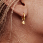 Detalle del Pendiente Huggie Trébol Amalia dorado en la oreja