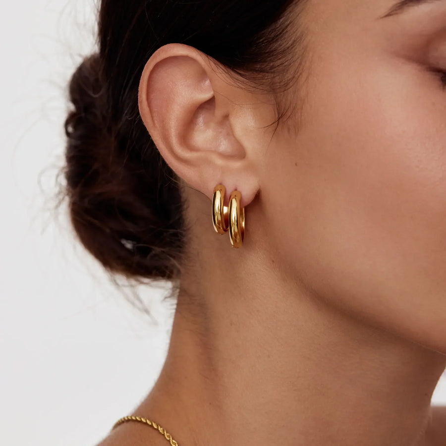 Detalle de los Pendientes Aro Volumen Siena dorados en la oreja