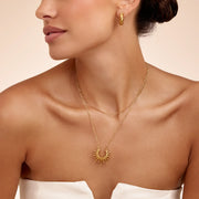 Detalle del Collar Sol Radiante Calista dorado en el cuello