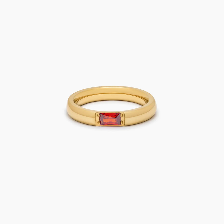 Anillo Piedra Natal Liora dorado con piedra roja sobre fondo blanco