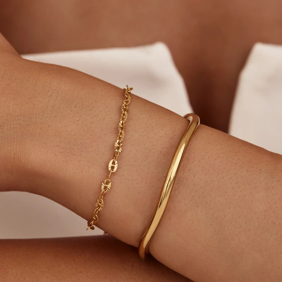 Detalle de la Pulsera Cadena Destellos Naia dorada en la muñeca