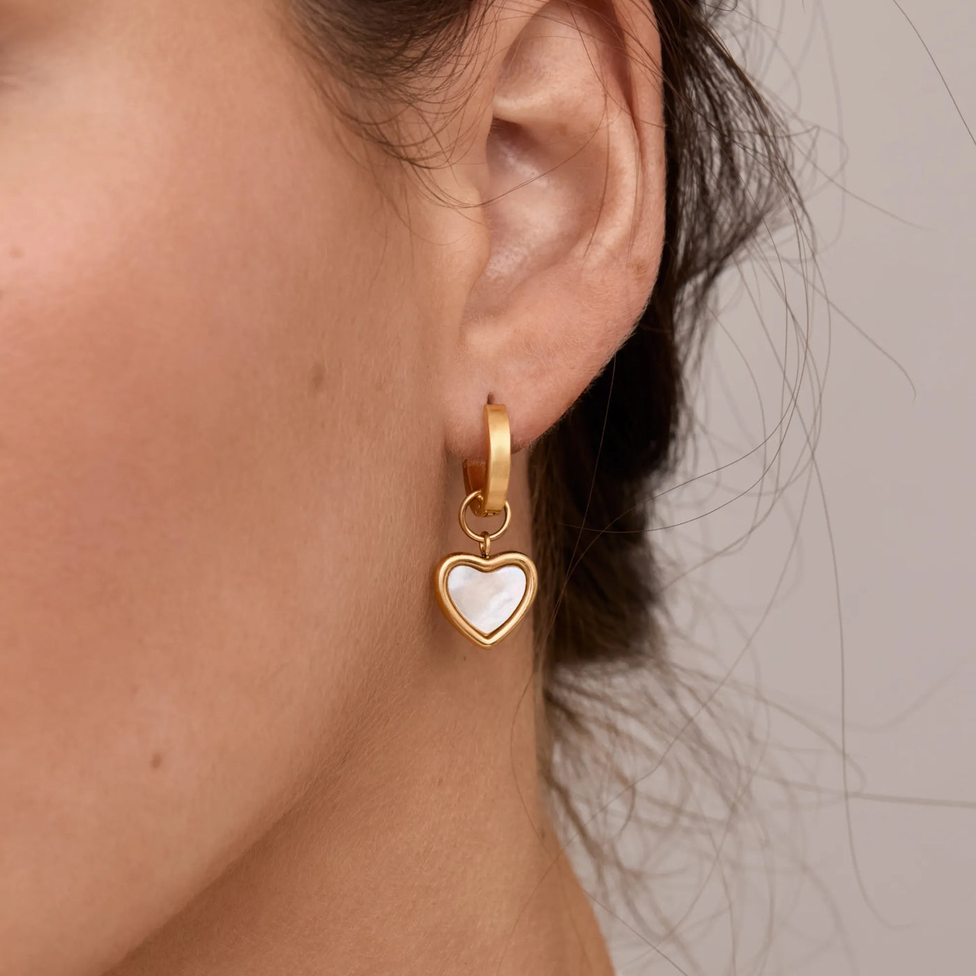 Detalle del Pendiente Huggie Corazón Eliana dorado en la oreja