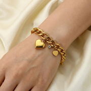 Mujer llevando la Pulsera Cadena Corazones Renata dorada