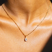 Detalle del Collar Gota de Luz Amira dorado en el escote