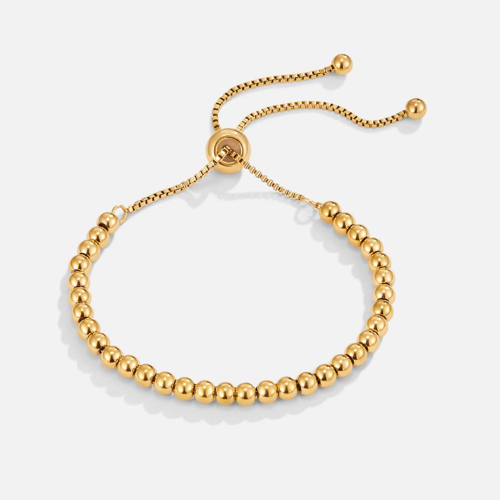 Pulsera Ajustable Esferas Soraya dorada sobre fondo blanco