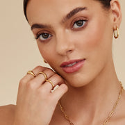 Modelo luciendo el Anillo Ondulado Nerea dorado junto al rostro