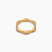 Anillo Ondulado Nerea dorado sobre fondo blanco con un reflejo suave