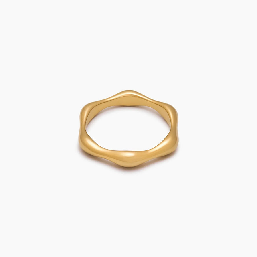 Anillo Ondulado Nerea dorado sobre fondo blanco con un reflejo suave