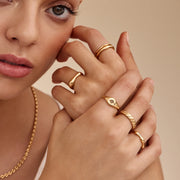 Modelo luciendo el Anillo Trenzado Siena combinado con joyas doradas